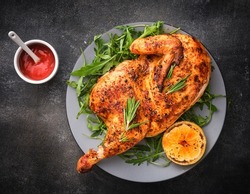 Half roasted chicken Piri Piri served with lemon and sauce . Grilled poultry.