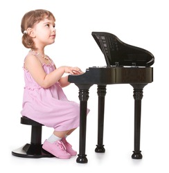 little girl playing on a miniature piano . kid with musical instrument 