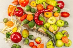 Trendy ugly vegetables and fruits. Assortment of fresh pepper, beans, cucumber, tomato, pumpkin, apples. Cooking organic ugly food concept. Stone concrete background, top view