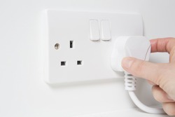 Hand Putting Plug Into Electricity Socket