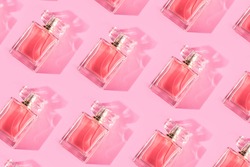 Pattern bottles of woman perfume on a pastel pink background, top view, flat lay. Mockup of pink fragrance perfume bottle mockup on pastel pink empty background