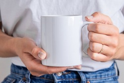 White coffee mug in the hands of the girl for presentation custom sublimation print. Blank mug photo mockup template