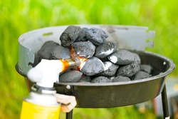 Ignition of coals by a gas burner on a brazier, wooden briquettes for a grill