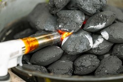 Ignition of coals by a gas burner on a brazier, wooden briquettes for a grill