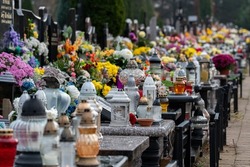 All Saints' Day and burning candles next to flowers on the graves. Candles on graves symbolize the memory of the dead on November 1. Catholic cemetery during All Saints' Day.