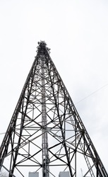 Cell phone relay tower. Metal mast. Metal structure with mounted relays. Steel structure against the sky.