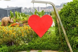 Big red heart hanging from an iron frame in the park