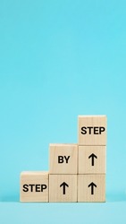 Step by step text. The word step by step on wooden cubes. Achieve