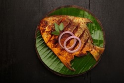 Fish fry ,arranged in a round wooden base lined with banana leaf
