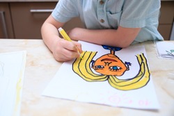 A boy draws a portrait of his mother, top view