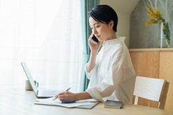 Woman making a phone call while working remotely