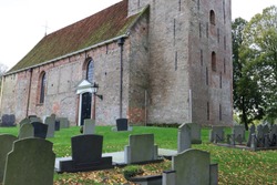 old and characteristic Dutch cemetery near a church. photo was taken on a autumnal and cloudy day.