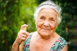 close up portrait of a senior woman in a garden. Very old lady of eighty years old outdoor in summer