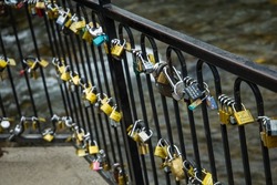 A black iron wall or railing of locks symbolizing love.