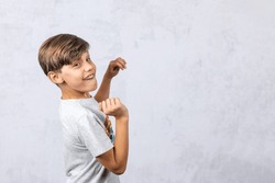 a cute autistic elementary school boy on a white gray background with copy space.