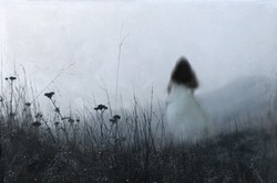 An out of focus, blurred ghostly woman wearing a white dress, running away from the camera. On a misty winters day in the countryside. With an artistic, textured, edit.