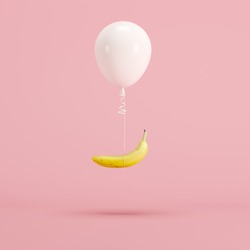 Floating White balloon and banana on pink background. minimal fruit idea concept.