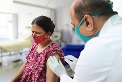 Vaccination in india, Medical worker or doctor giving vaccine injection to a mature woman at hospital to protect from coronavirus or covid-19. omicron cases in india