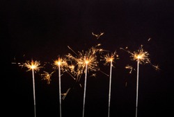 A lot of burning sparklers on isolated on black background. Birthday party background.