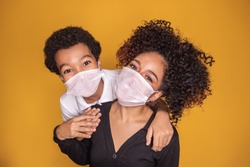 Portrait of young African American mother with toddler son using mask. mother and son wearing mask to protect covid 19, quarantine. Stay at home concept. 