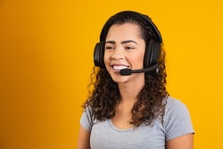 Contact the call center service. Customer support, female sales agent. Caller or operator of telephone operator or business woman in headset. Afro young woman. Zoom conference. yellow  background