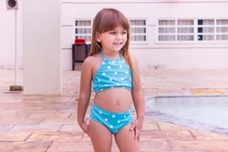 cute little caucasian girl in bikini smiling looking at camera