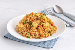 Chinese Asian Egg and Vegetable Fried Rice on a White Plate on the White Background.