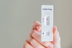 Hands holding Covid-19 rapid antigen test cassette with negative result of rapid diagnostic test at home