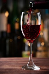red wine pouring from bottle into glass