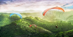 Paragliding multicolor. Paraglider flying over Landscape from the background Beauty nature mountain landscape of the sky. Paragliding Sports. Concept of extreme sport, taking adventure challenge.