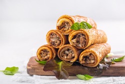 Savory pancake rolls stuffed with ground meat, rice and fried onion. White background, copy space.