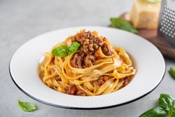 Tagliatelle al ragu - italian pasta with meat bolognese sauce. High angel. Extra hard cheese on background.