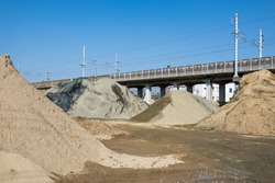 Piles of sand and rock aggregate in construction yard