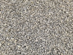 Gray small rocks ground texture. black small road stone background. gravel pebbles stone seamless texture, marble. dark background of crushed granite gravel, close up. grey clumping clay