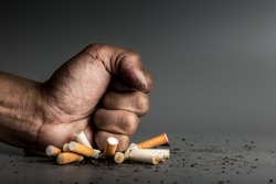 Hand fist smash or punch on cigarette.Cigarettes is addictive to be cancer.smoking reduction campaign in World No Tobacco Day.