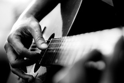 Close up of man's hands playing acoustic guitar. Musical instrument for recreation or hobby passion concept.