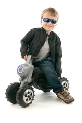 Boy on child's motorcycle, on egg white background.