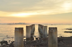 The concrete pillar are in the sea harbor with pastel sky.