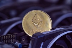 Ethereum coin (ETH) is placed on a cryptocurrency miner made of VGA cards. Proof-of-Stake (PoS) Concept.