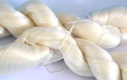 White raw silk extracted from Silk Cocoons that were produced by Silkworms.