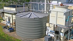 Two large cooling towers and a large plastic water tank