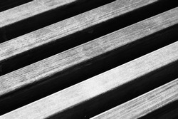 Closeup of wooden slats creating parallel lines and stripes across the page in black and white grayscale.