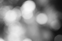 Gorgeous dreamy blurry abstract bokeh of bright lights floating around the atmosphere in black and white.