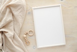 Nursery frame mockup, vertical white wooden frame mock up for baby room art, pregnancy announcement, top view, flat lay.