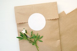 Round blank sticker mockup, circle tag mock up on kraft paper gift bag, adhesive round product label.