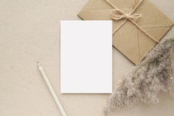 Notecard, postcard, greeting card mockup, brown envelope, pampas grass, blank letter paper or note paper for design or text presentation.