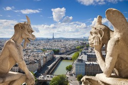 Notre Dame of Paris: Stryge and demon, most famous of all Chimeras, overlooking the skyline of Paris at a summer day (composition)