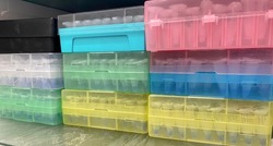 Multiple colorful boxes and racks filled with temperature-sensitive biological specimens and samples stored in a laboratory freezer at low temperature for extended preservation.