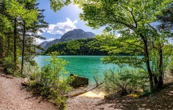 On the shore of a mountain lake. Lakeshore in mountains. Beautiful lake in mountains. Mountain lake view