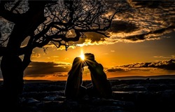 Silhouette of a couple in love kissing at sunset. Couple in love kissing at sunset. Falling in love at sunset. Romantic dating at sunset